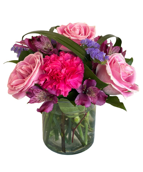 Vibrant and colourful arrangement designed in a clear cylinder vase.