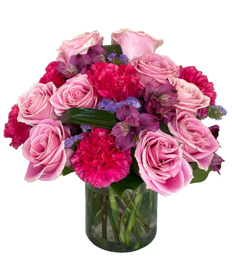 Vibrant and colourful arrangement designed in a clear cylinder vase.