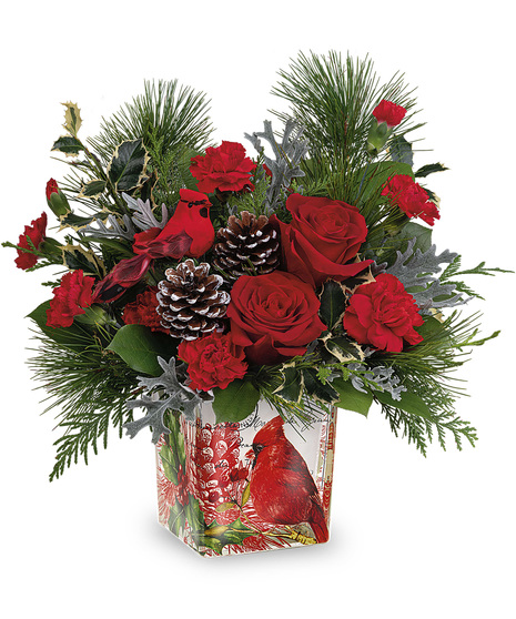 Christmas flowers in a keepsake vase adorned with a red cardinal