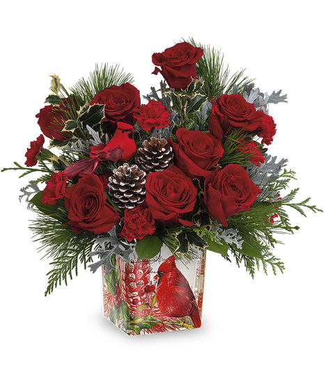 Christmas flowers in a keepsake vase adorned with a red cardinal