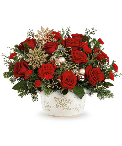 Christmas flowers arranged in a white vase with snowflakes on it.