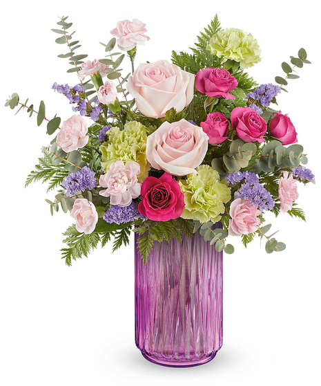 Gleaming Meadow Bouquet with pink roses, green carnations, and lavender statice, arranged in a glowing pink lantern vase.