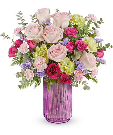 Gleaming Meadow Bouquet with pink roses, green carnations, and lavender statice, arranged in a glowing pink lantern vase.